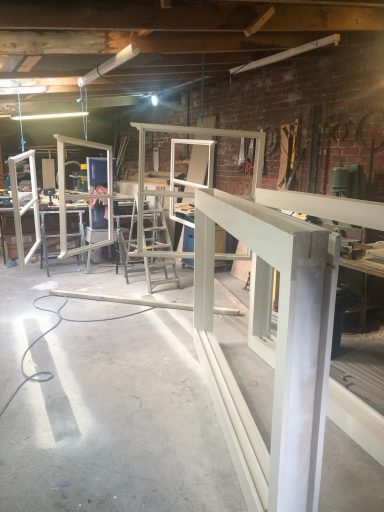 Sash window frames being spray painted in our workshop
