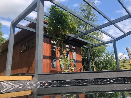 Black pergola with pond